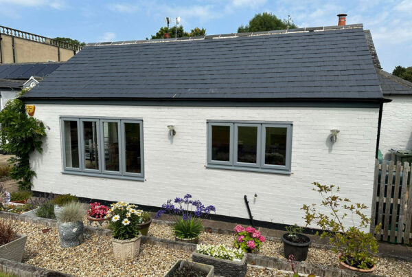 new grey stormproof windows on a white brick building