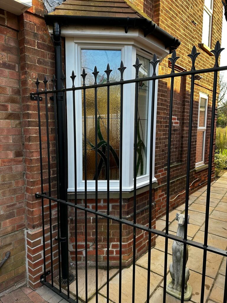 a red brick home with white casement windows