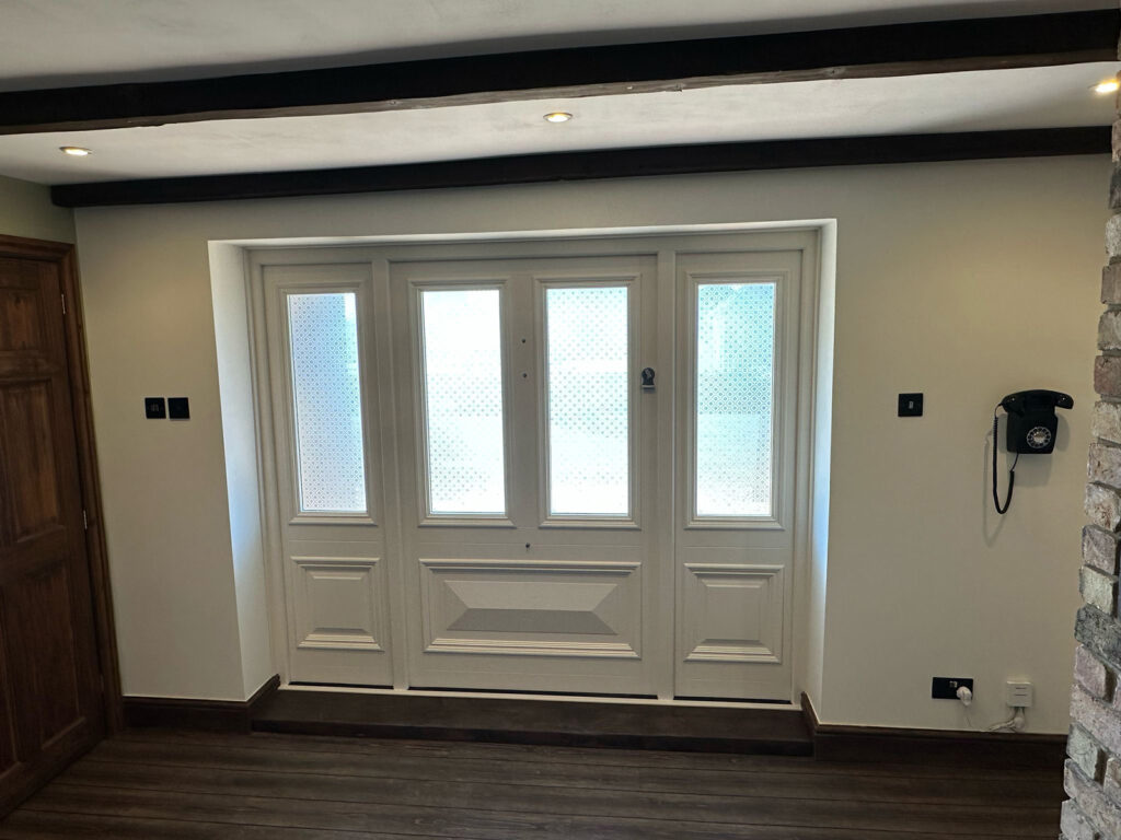 an internal shot of a white front door with sidelights