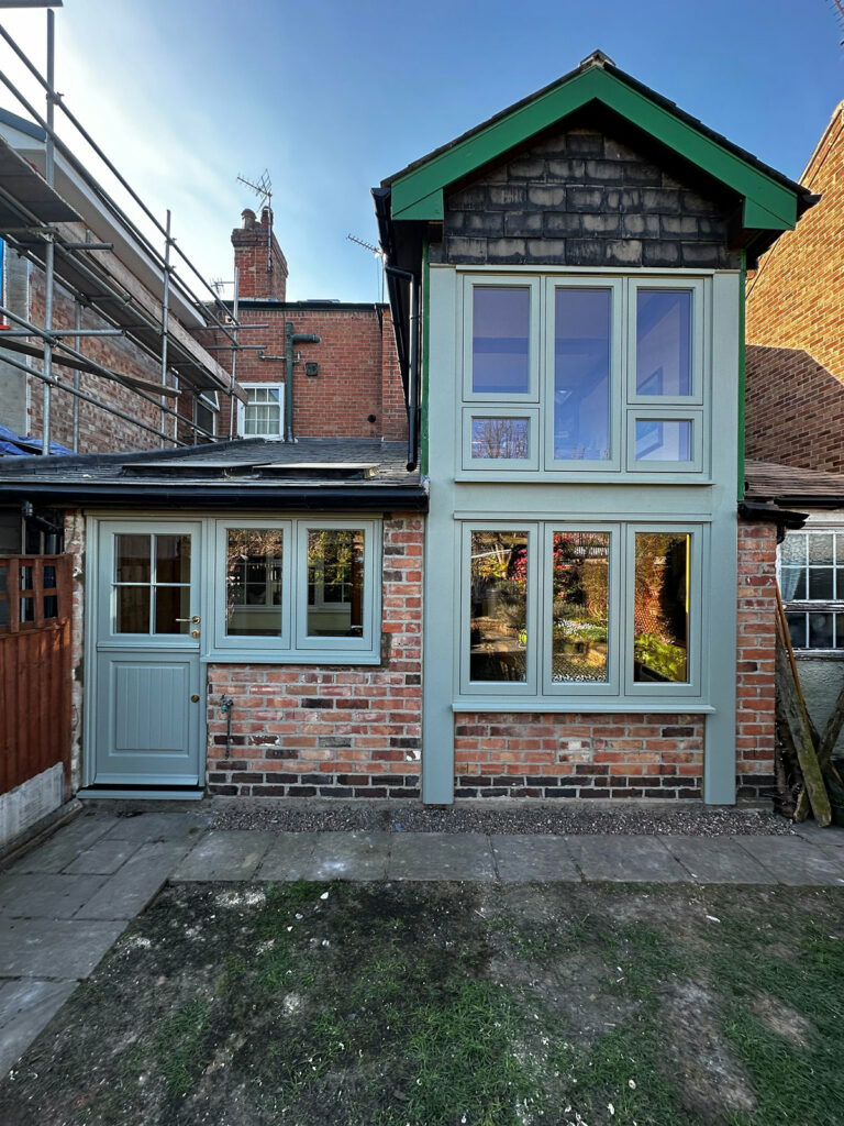 green casement windows and a stable door