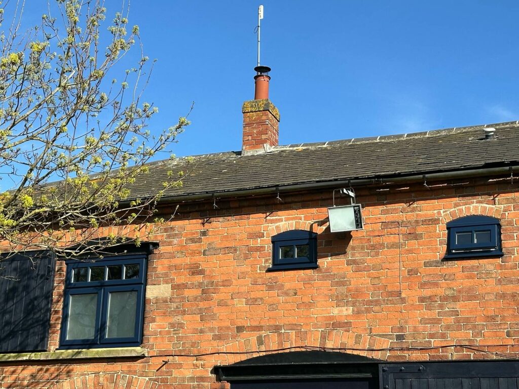 a converted barn with new lipped casement windows in oxford blue