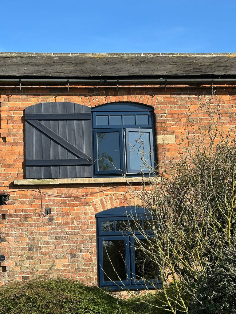 a converted barn with new lipped casement windows in oxford blue