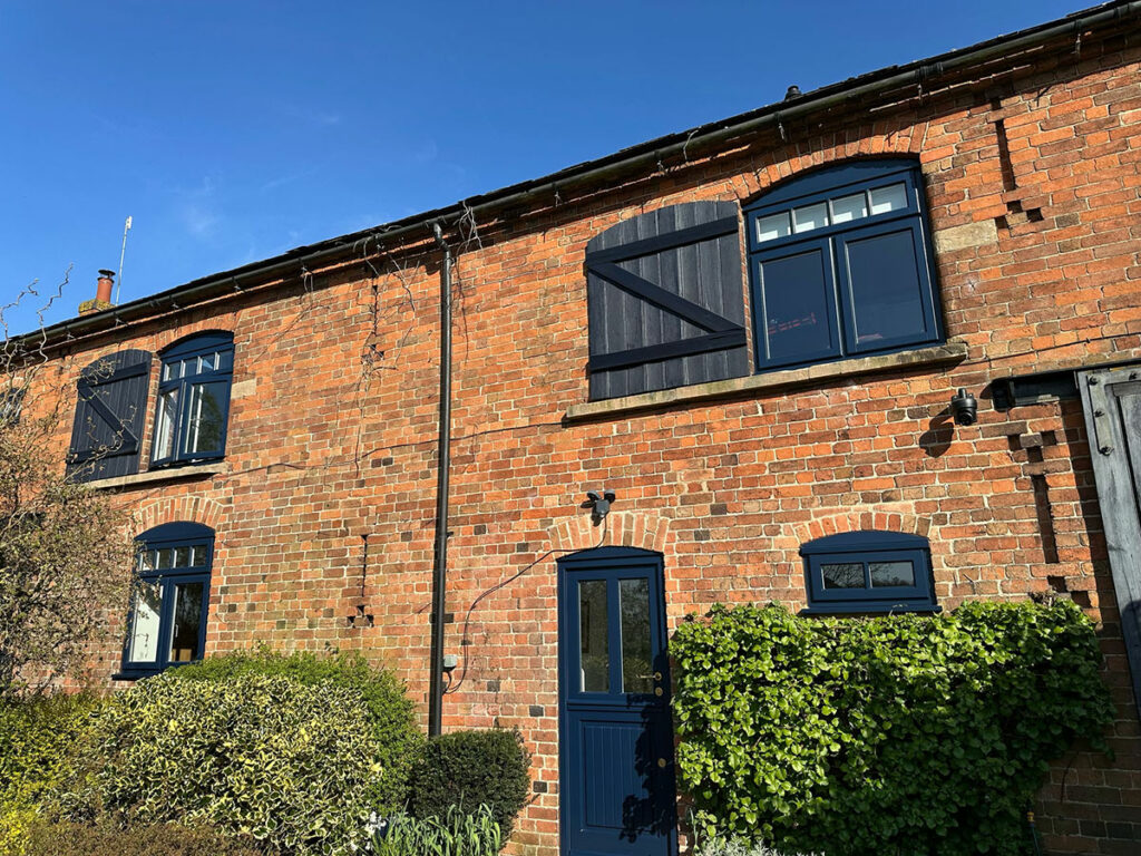 a blue stable door on a red brick converted barn