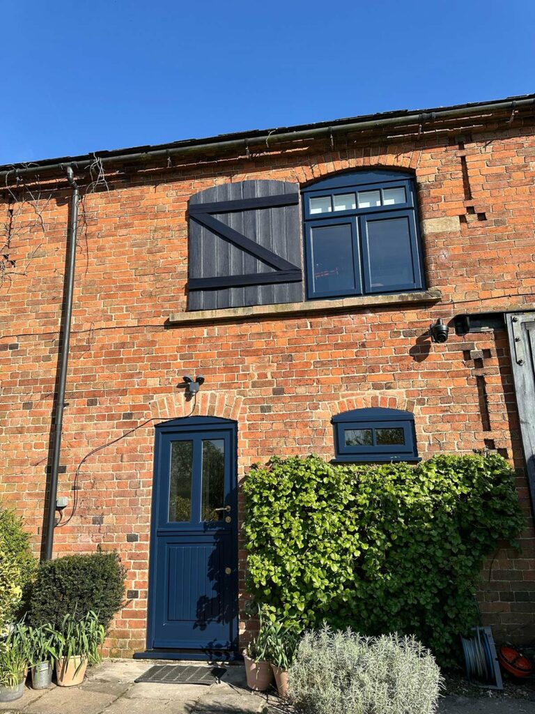 a blue stable door on a red brick converted barn