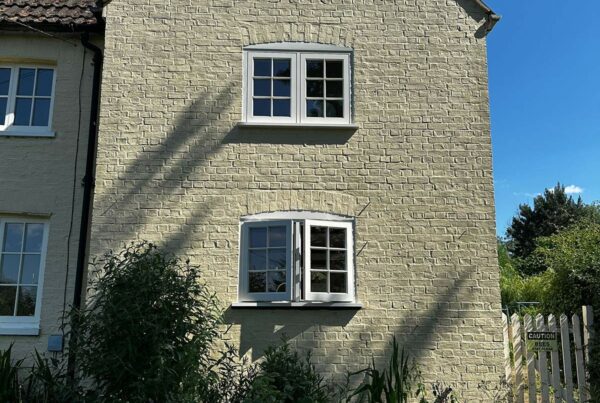 two sets of casement windows on the side of a building