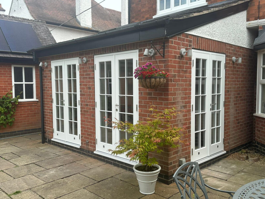3 sets of white french doors at the rear of a property