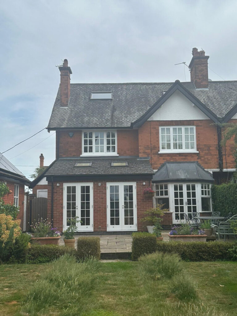 an edwardian style home with white windows and doors
