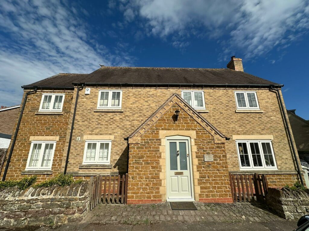 a large home with white windows and a stone facade