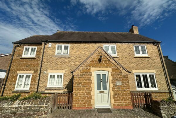 a large home with white windows and a stone facade