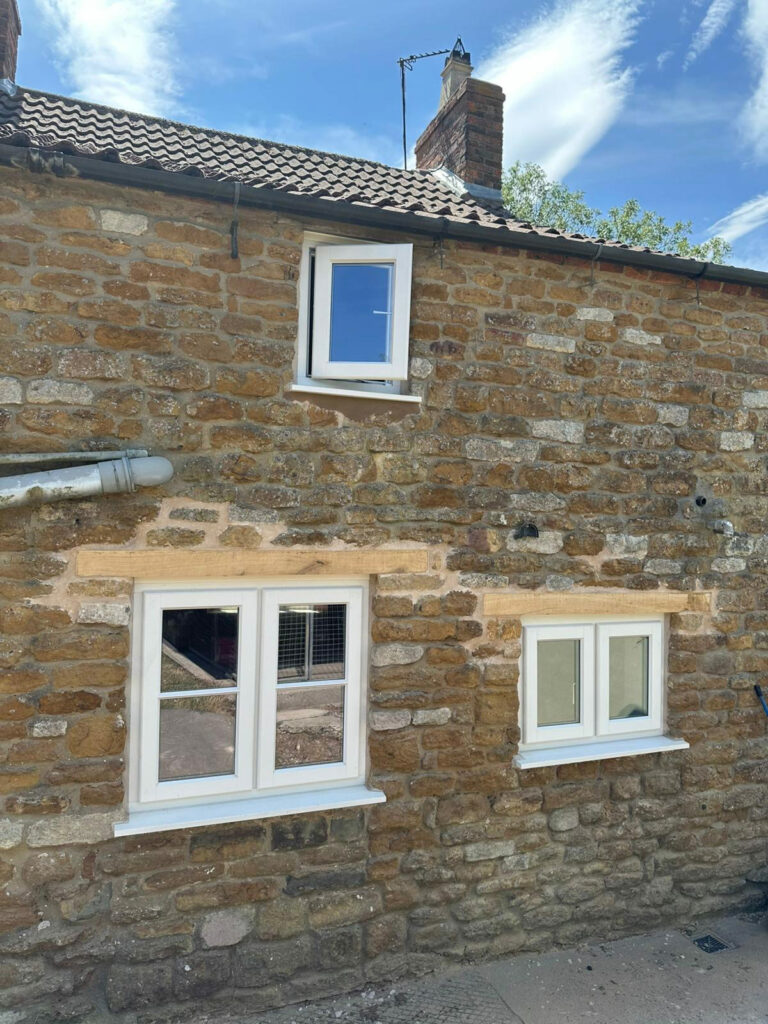 white stormproof windows on a stone cottage