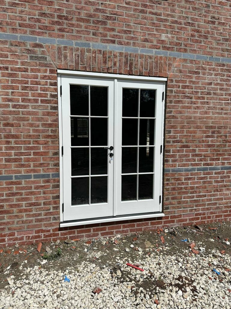 a set of white french doors on a building site