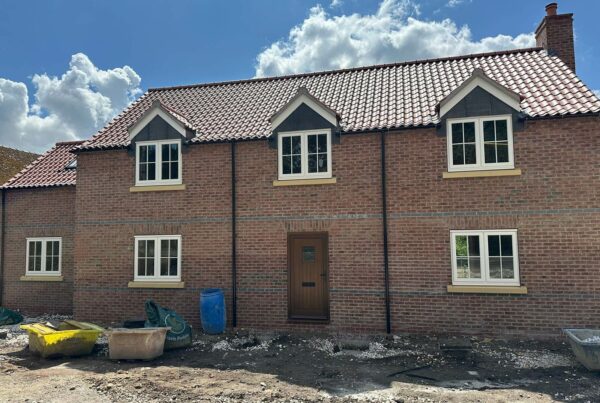 a newly built red brick home on a building site