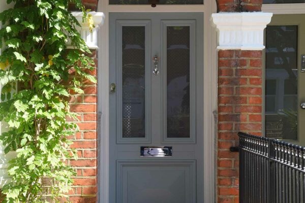 a blue townhouse door with a mosaic stone walkeway