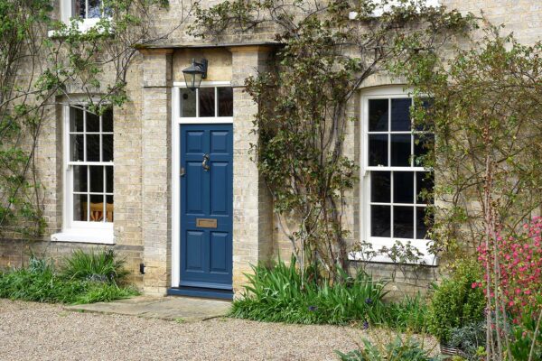 a solid blue front door with sash windows to either side
