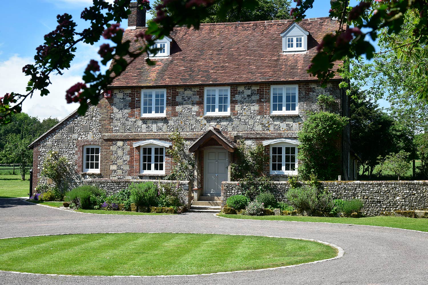a beautiful stone country house with a green in front of it
