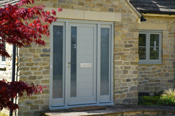 a french grey contemporary front door on a cotswolds stone property
