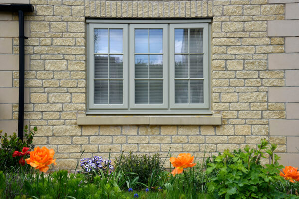 french grey stormproof windows behind orange and purple flowers