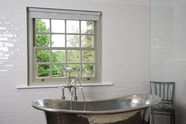 a georgian sash window in a bathroom with a traditional copper bathtub