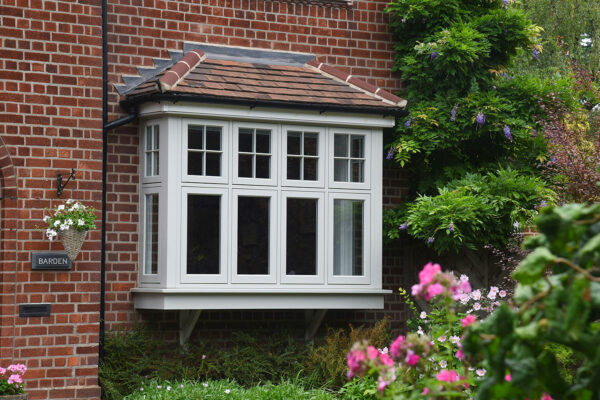 a bay of casement windows on a red brick home