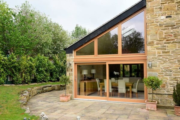 a set of oak stained sliding doors with a bespoke arched toplight