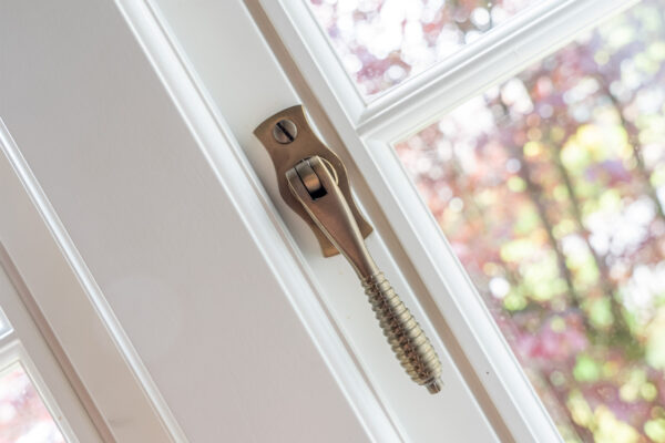 a brass window handle on a white window