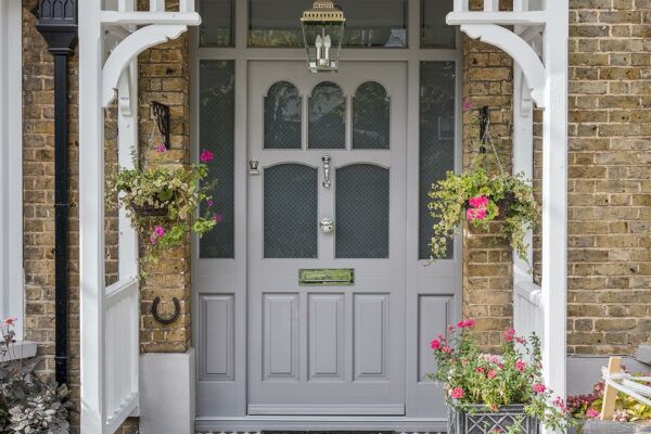 an elaborate front door with sidelights and toplight under a charming canopy