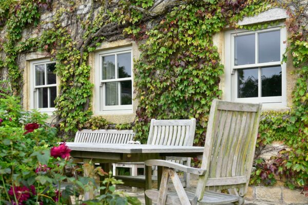 three individual sash windows behind garden tables and chairs
