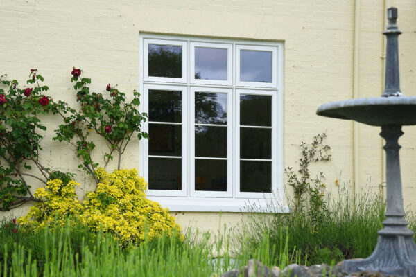 a large set of deco casement windows behind a water fountain