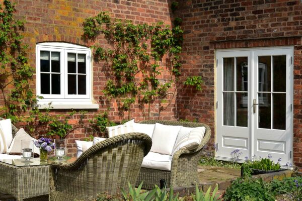 a set of french doors and casement windows on a garden patio area