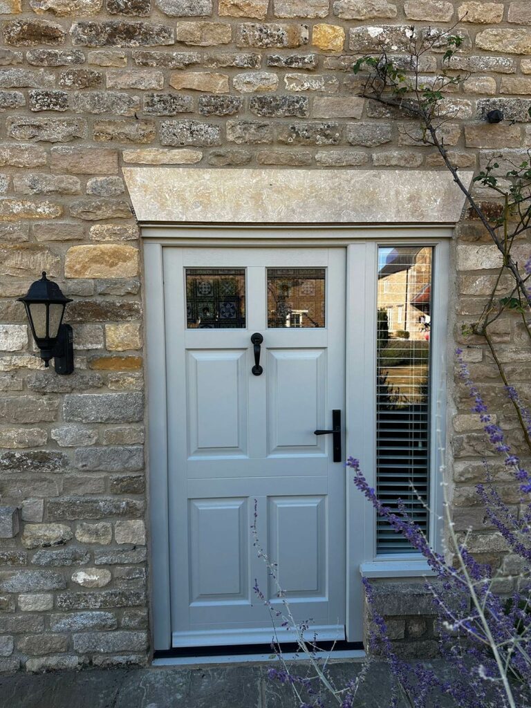 an off white front door with a large accompanying flag window