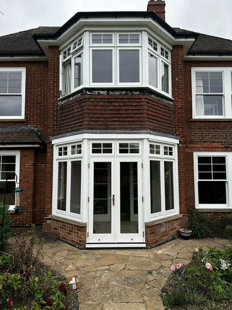 a beautiful deco set of French doors beneath a large set of casement windows