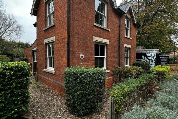 a red brick detached home with white sash windows