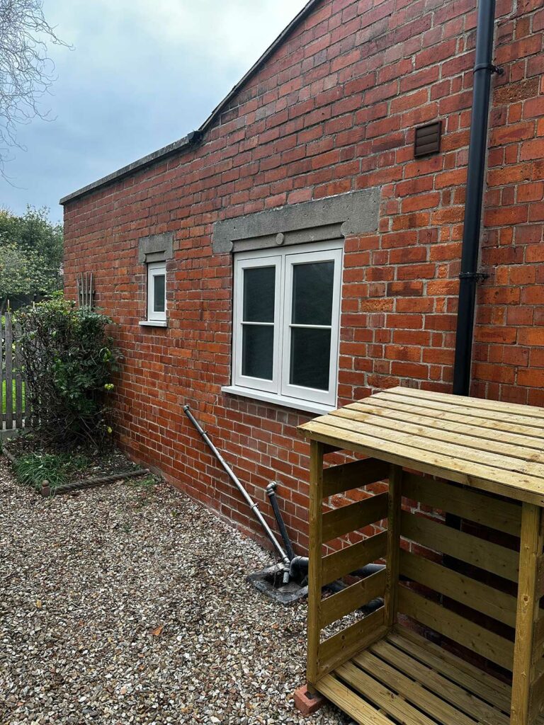a red brick detached home with white sash windows
