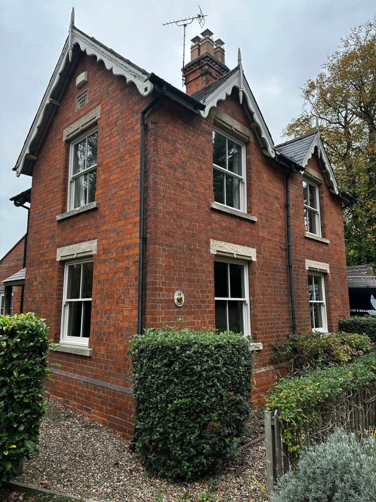 a red brick detached home with white sash windows