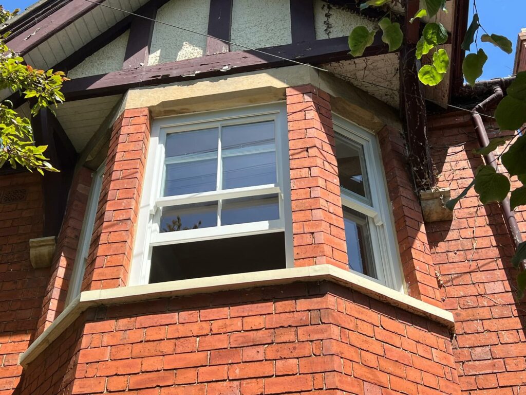 a slim sash bay window between stone mullions