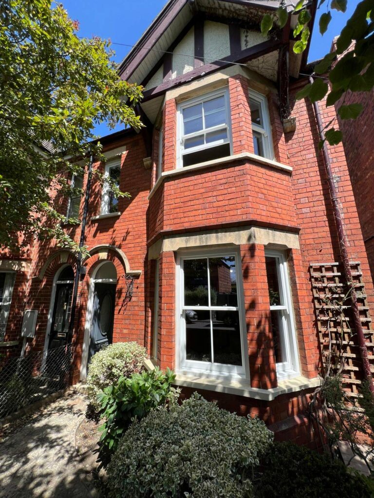 a red brick townhouse with white sash windows