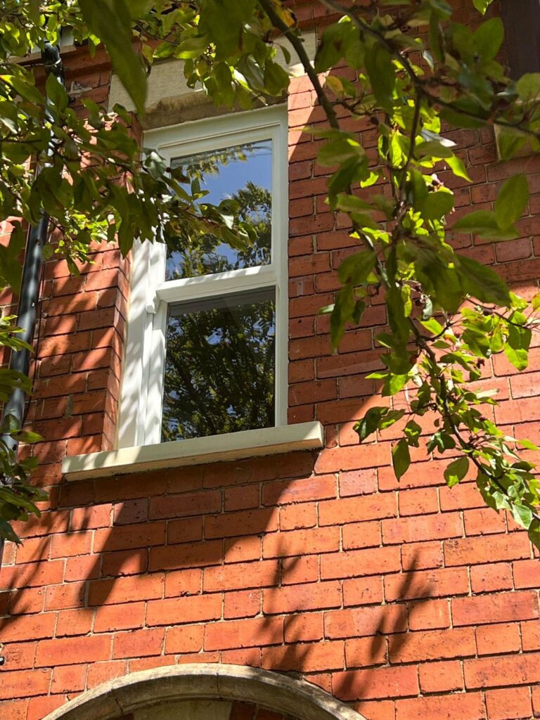 a red brick townhouse with white sash windows