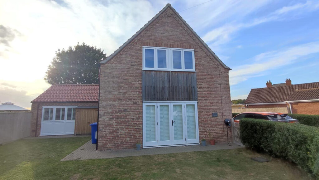 white timber windows and doors on a traditional red brick home