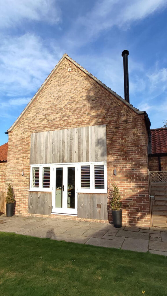 white timber windows and doors on a traditional red brick home