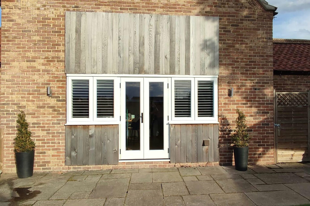 white timber windows and doors on a traditional red brick home