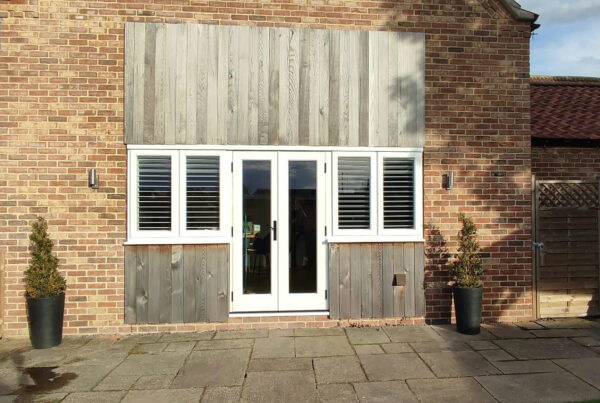 white timber windows and doors on a traditional red brick home