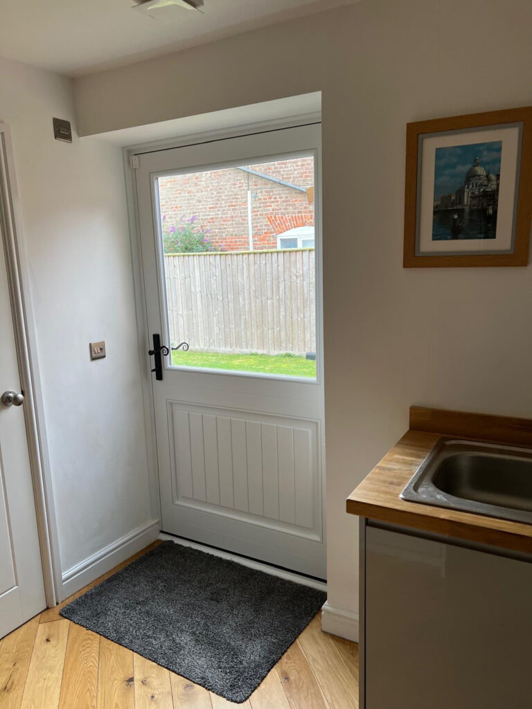 white timber windows and doors on a traditional red brick home