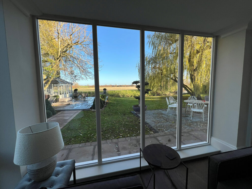 large fully glazed panels of glass overlooking a picturesque garden