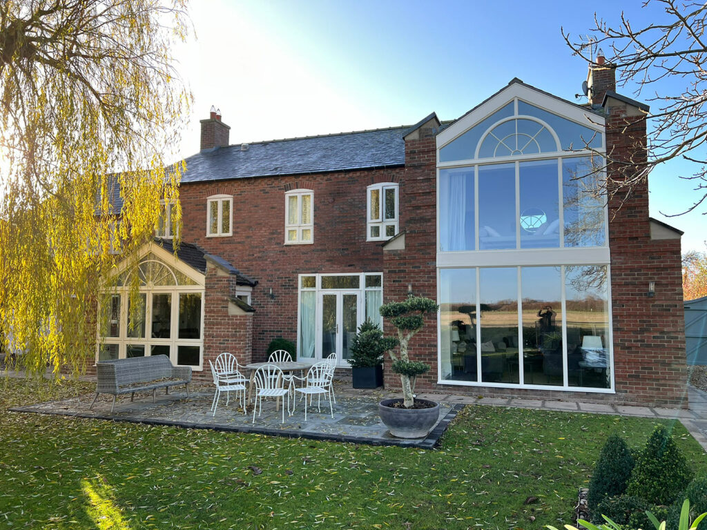 a beautiful red brick home with large, feature casement windows