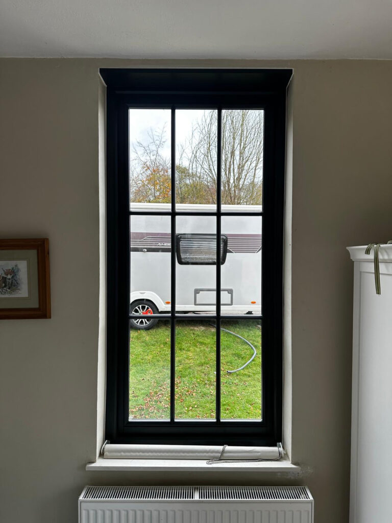 a dark casement window with georgian bars