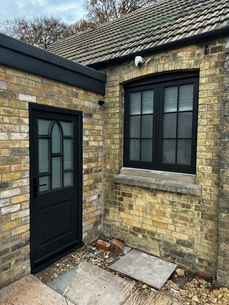 a dark front door and flush casement window