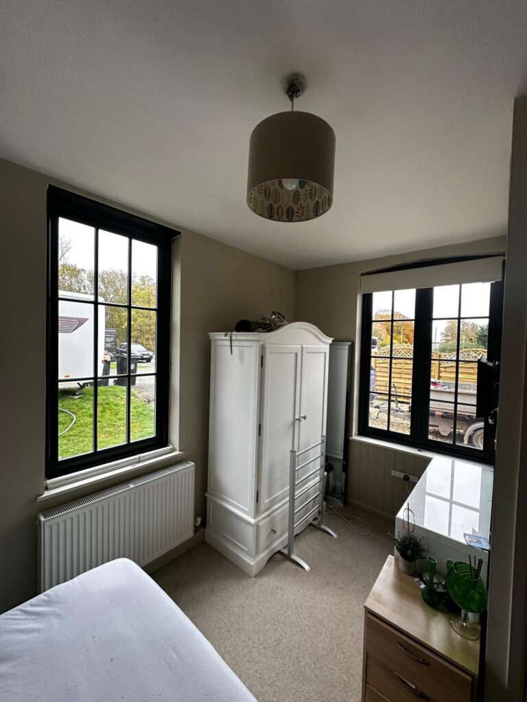 two dark casement windows in a spare room