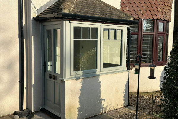 the porch of a house with a victorian style front door and lipped casement windows