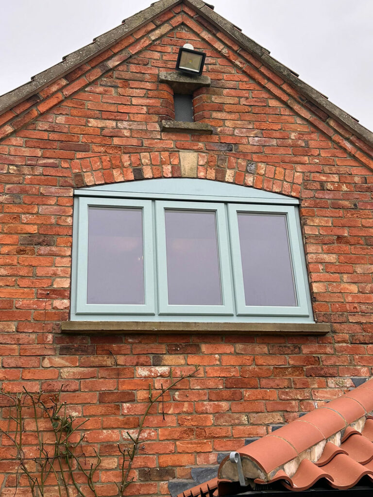 a triple stormproof window on a red brick house