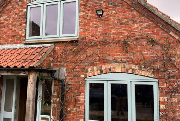 a red brick house with light blue stormproof windows